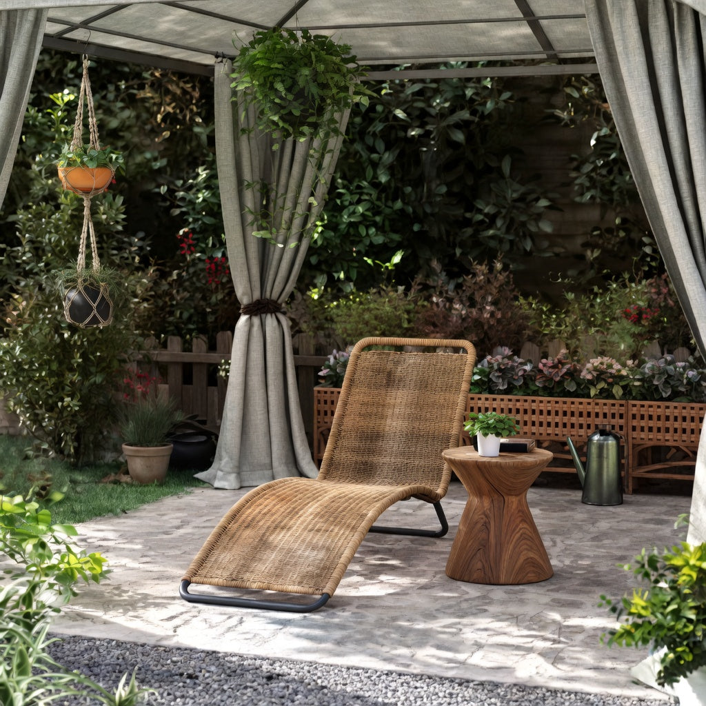Chaise longue en rotin naturel extérieur installée sous un gazebo dans un jardin végétalisé