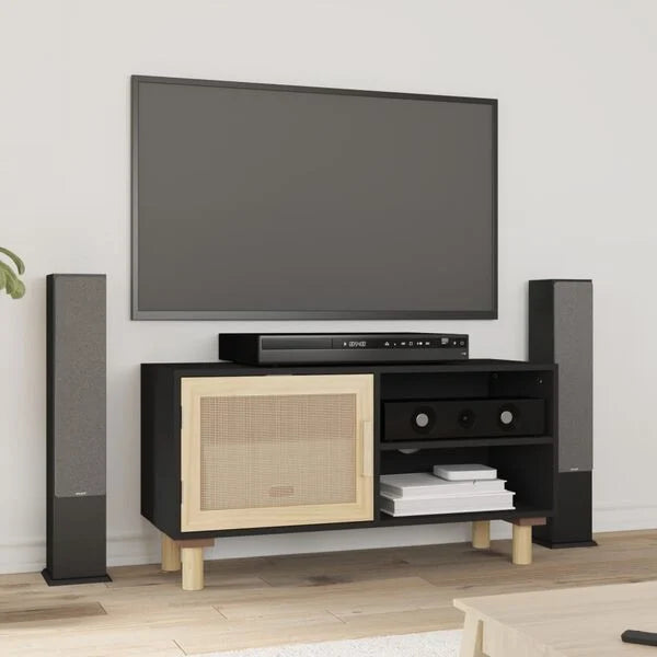 Meuble TV noir avec porte en rotin naturel beige posé sous un téléviseur dans un salon avec parquet clair et enceintes colonne