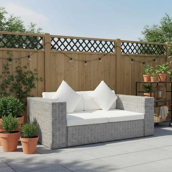 Canapé extérieur 2 places résine tressée gris avec coussins blanc crème sur une terrasse