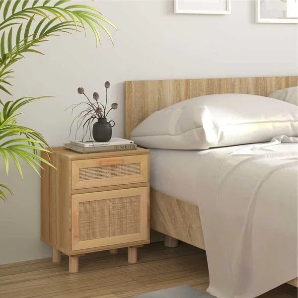 Table de chevet cannage rotin bois naturel avec tiroir et porte placée à côté d'un lit
