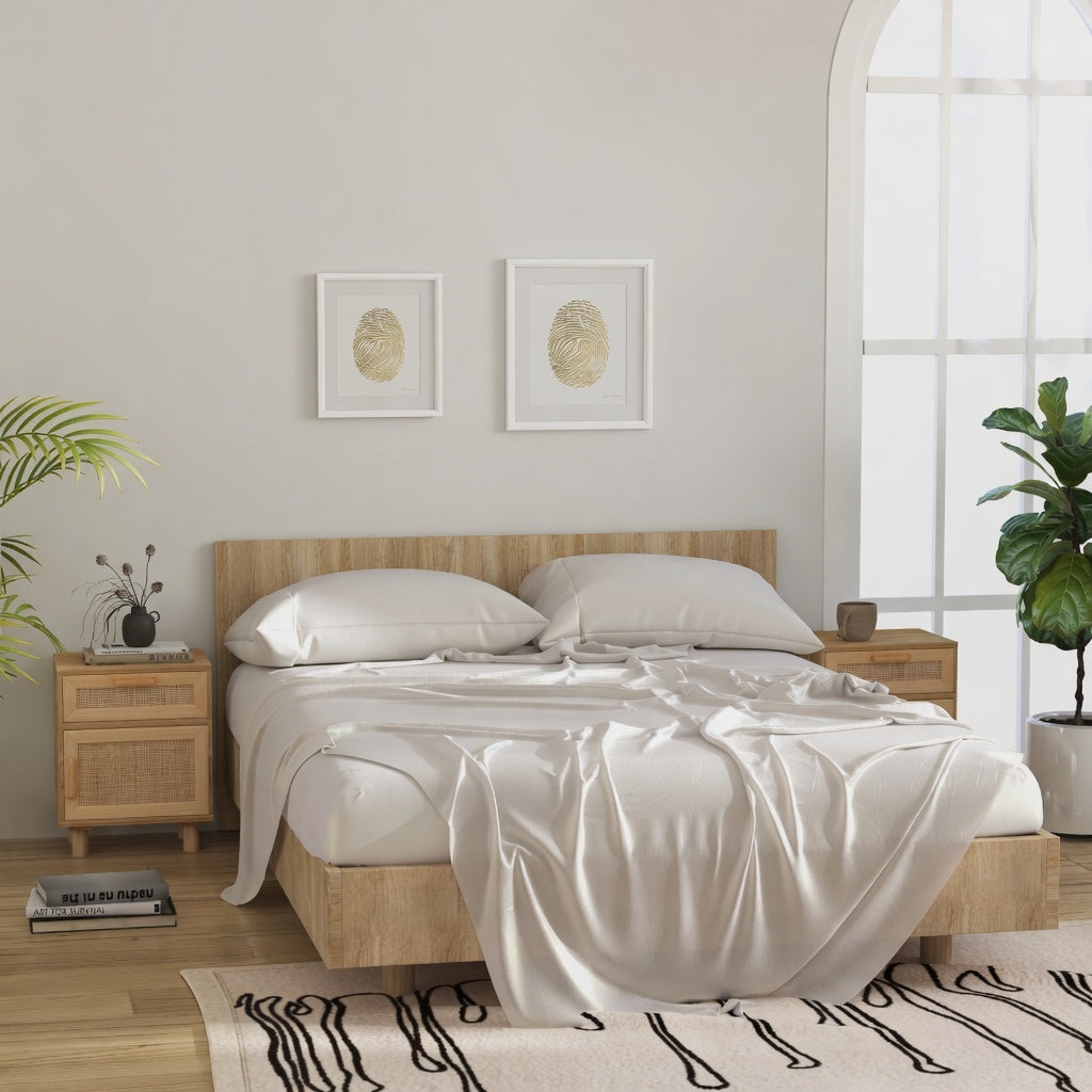 Deux tables de chevet en bois et rotin naturel posées de part et d'autre d'un lit dans une chambre claire